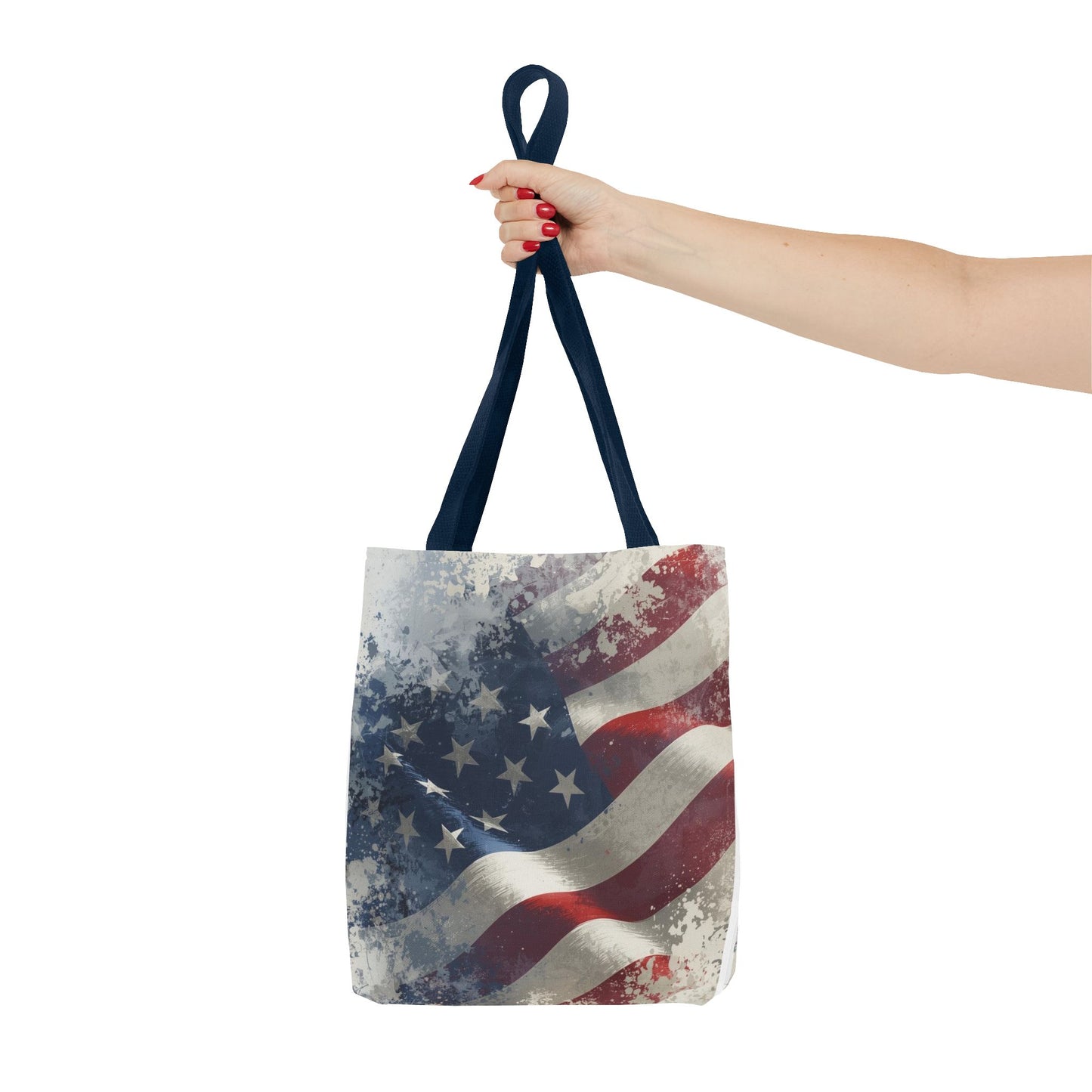 Tote bag with American flag design held by a hand on a white background