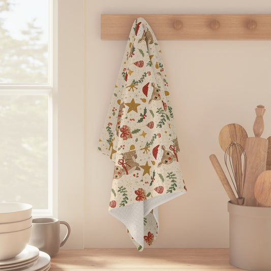 Decorative towel with Christmas patterns hanging on a wooden rack in a kitchen.