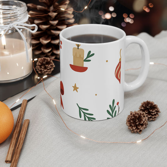 White mug with festive design on a table with candles, oranges, and pine cones.