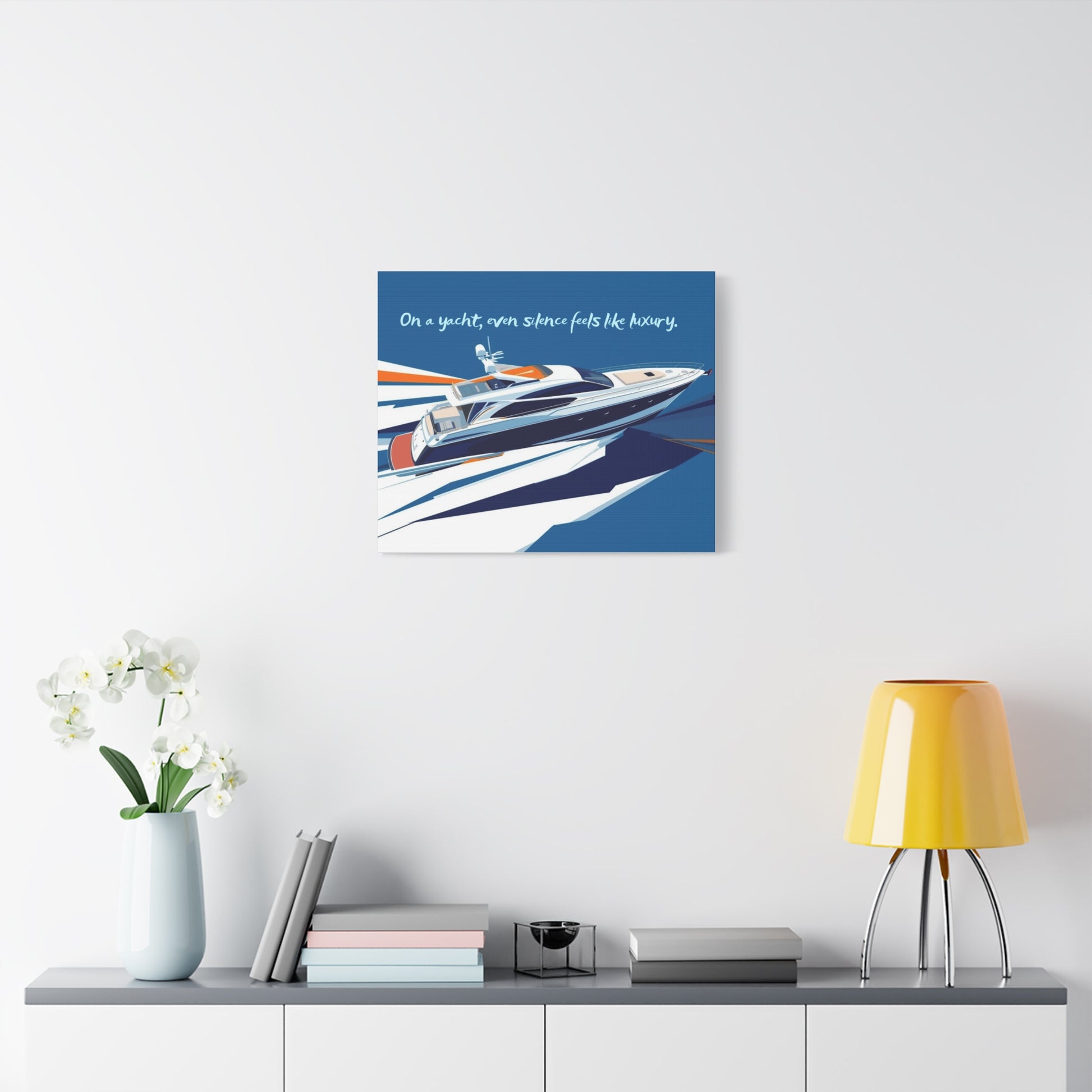 Canvas wall art of a yacht on a white wall above a shelf with decor items.