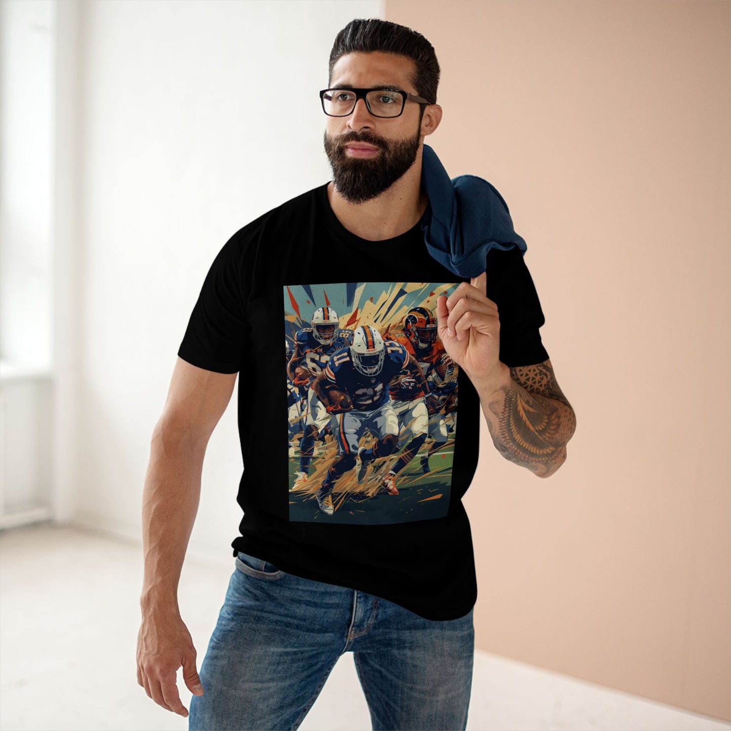 Man wearing a black t-shirt with a graphic design of a football player, standing indoors.
