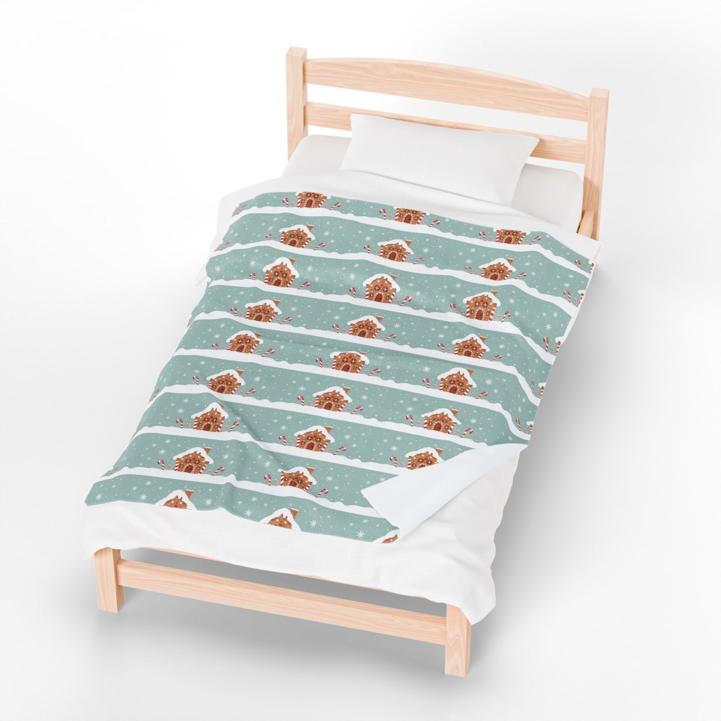 Children's bed with festive gingerbread and snowflake patterned duvet cover on a white background