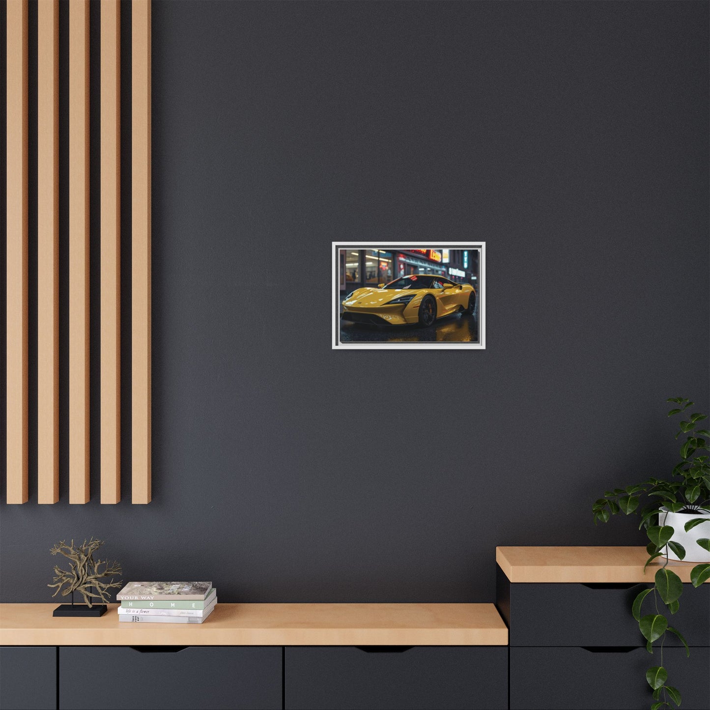 Framed artwork of a yellow sports car on a dark wall with wooden furniture and plants.