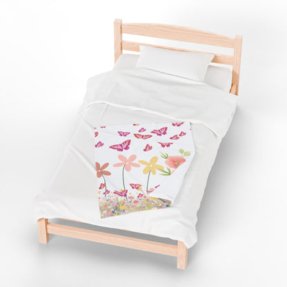 Children's bed with a floral-patterned blanket on a white background
