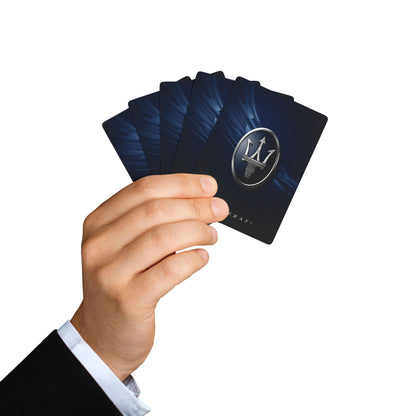 Hand holding a deck of black playing cards with a logo on a white background