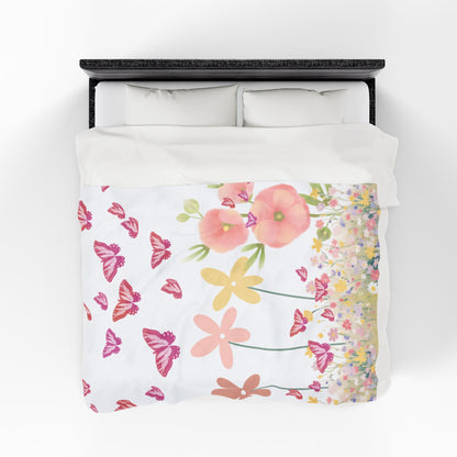 Floral and butterfly patterned blanket on a bed with a white background