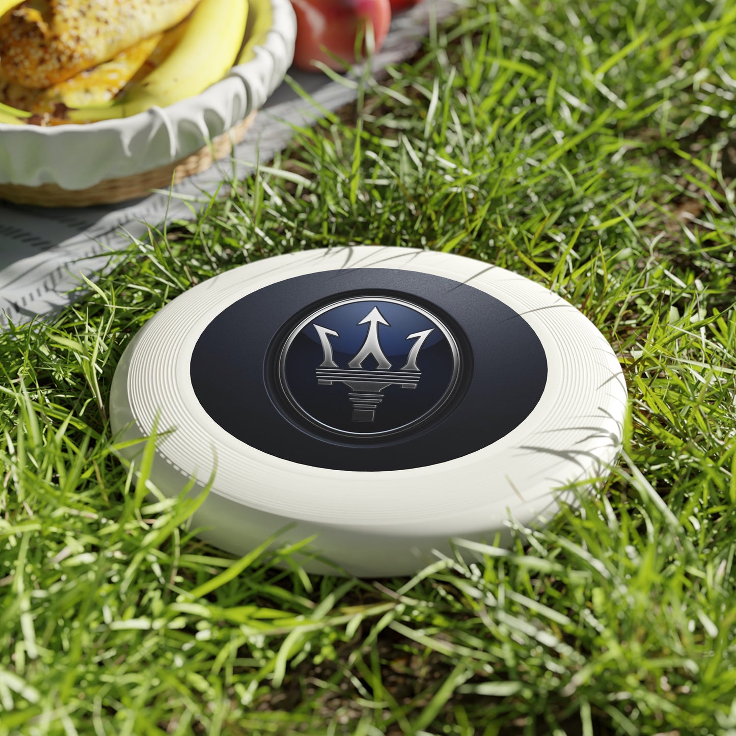 White frisbee with a logo on grass