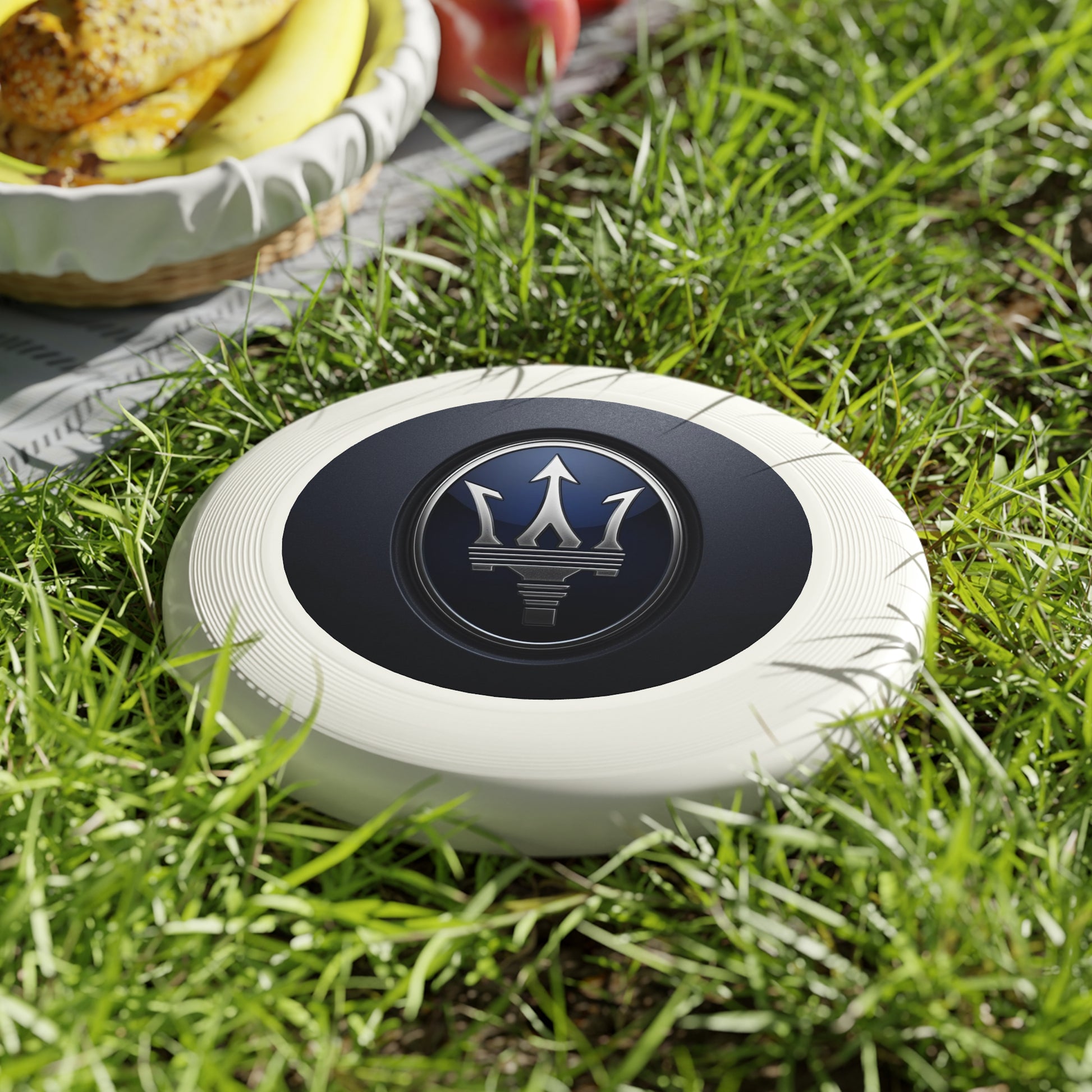 White frisbee with a logo on grass