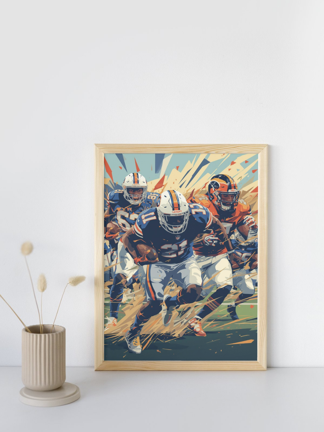 Framed artwork of football players in action on a white wall with a small plant.