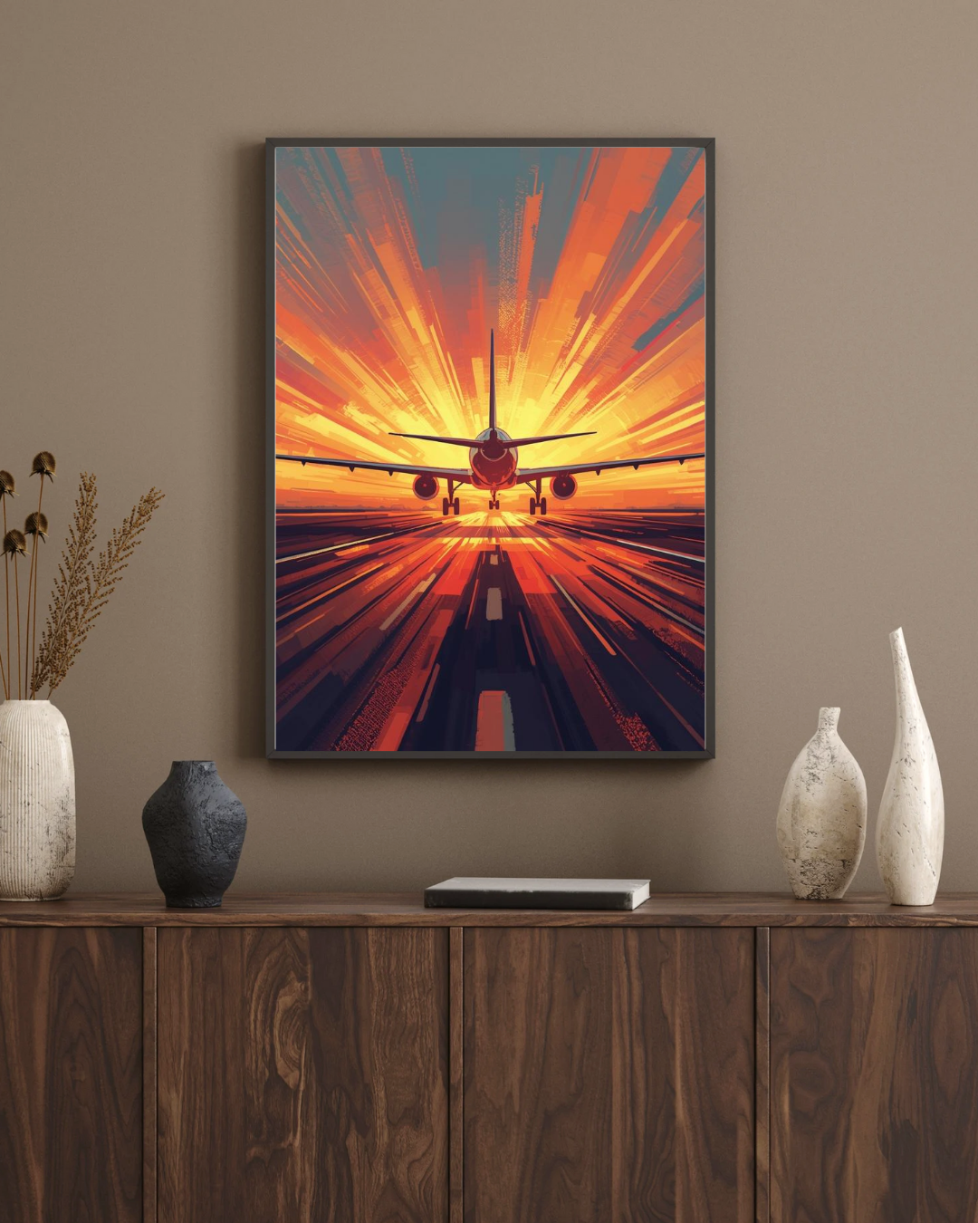 Framed artwork of an airplane taking off with a sunset effect, displayed on a wall above a wooden console table.