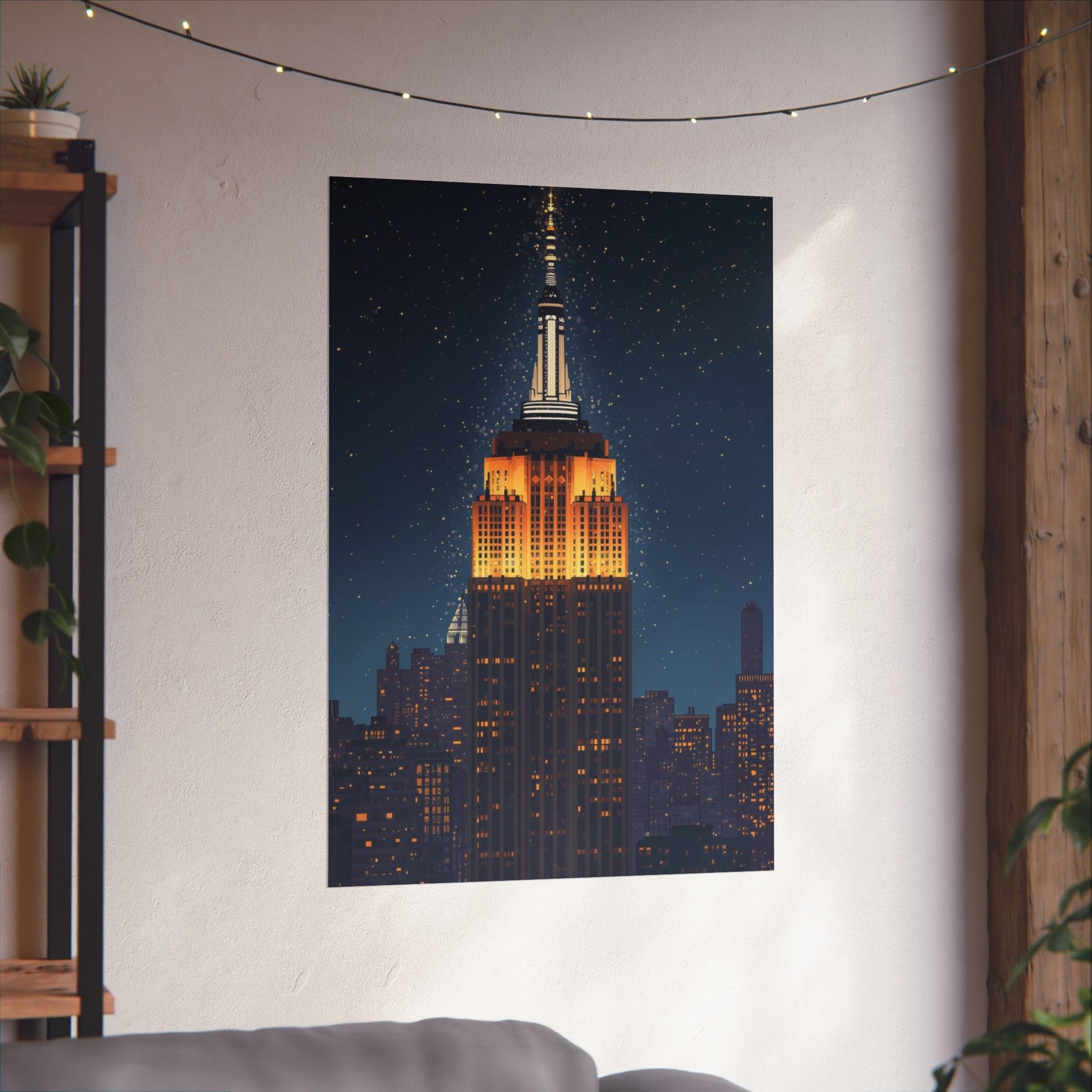 Poster of the Empire State Building on a wall in a room with a plant and shelf.