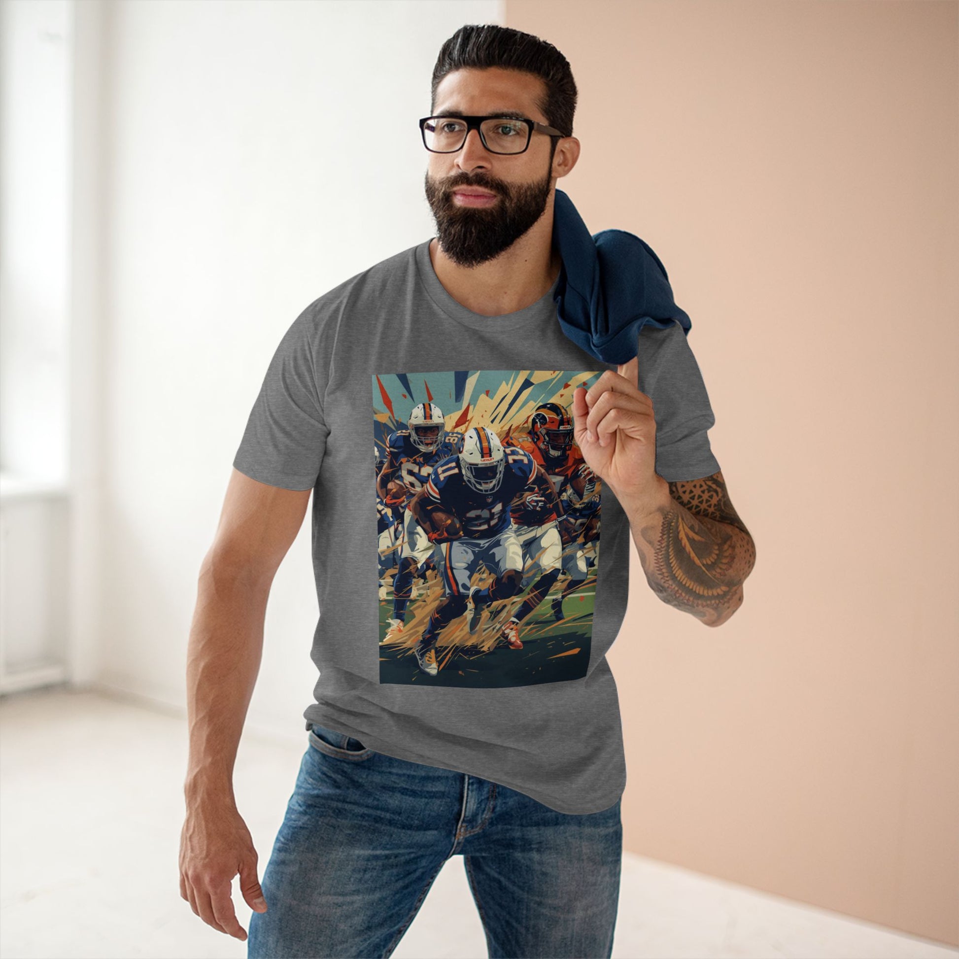 Man wearing a gray t-shirt with a colorful graphic design, standing indoors.