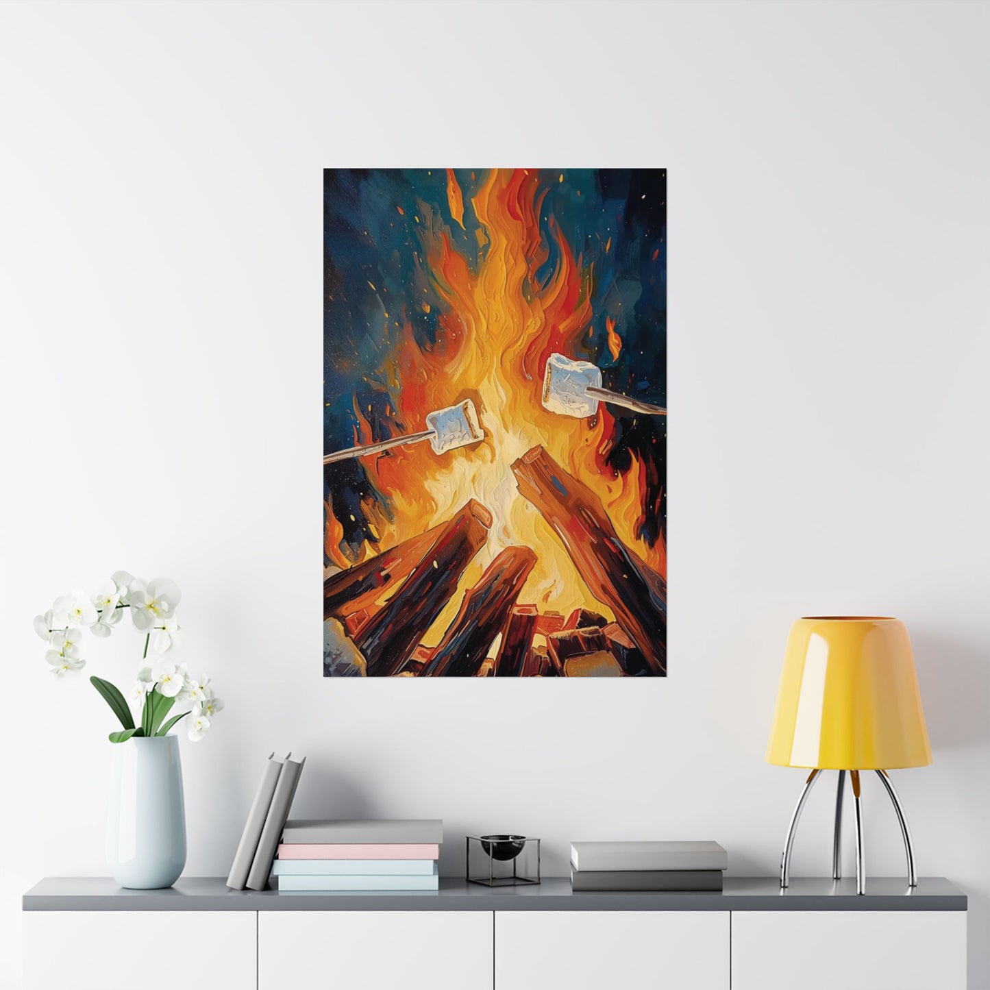 Art print of marshmallows roasting over a campfire on a wall above a shelf with decor items.