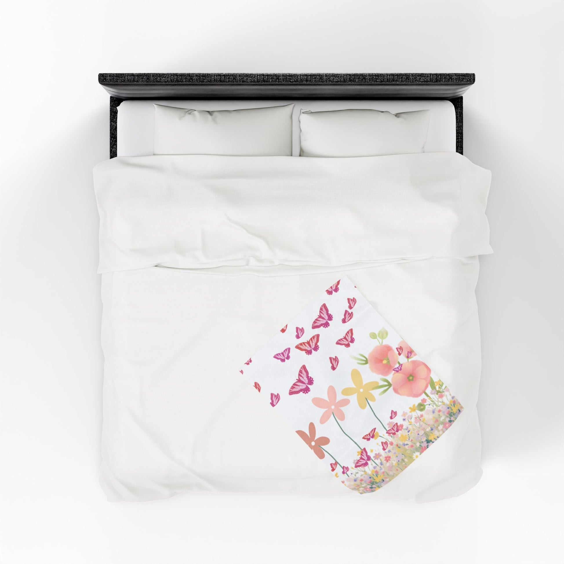 Floral and butterfly patterned blanket on a bed with a white background