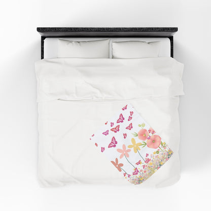 Floral and butterfly patterned blanket on a bed with a white background
