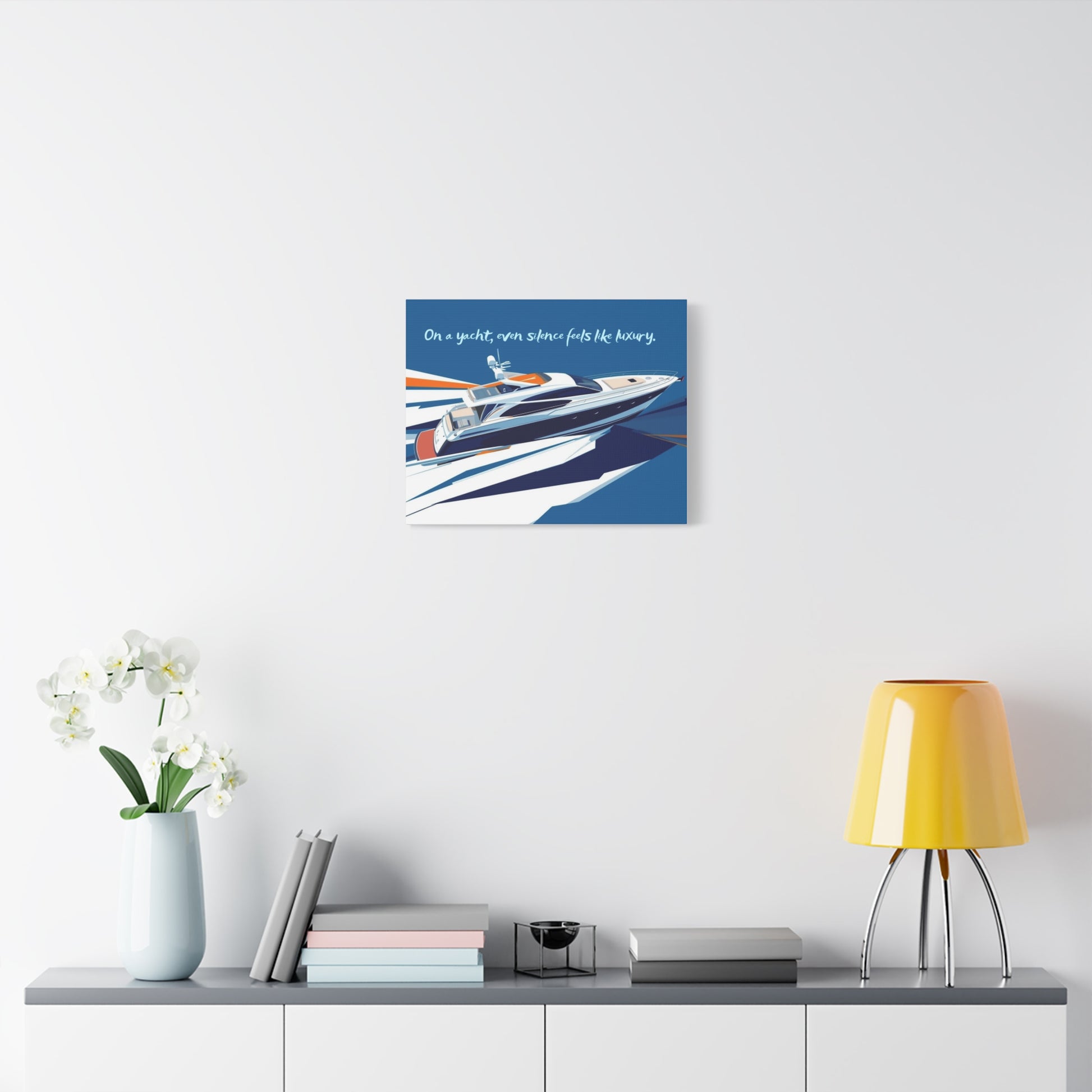 Canvas wall art of a yacht on a white wall above a shelf with decor items.