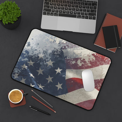 American flag mouse pad on a desk with a laptop, notebook, and coffee cup.
