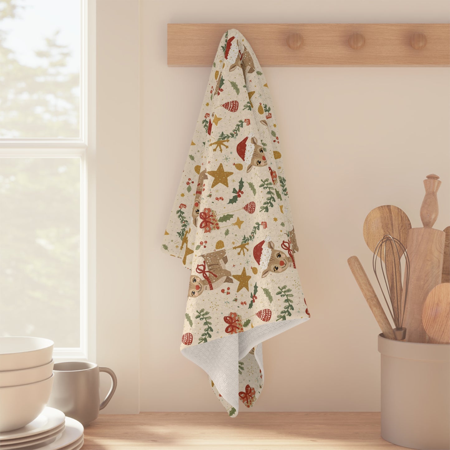 Decorative towel with Christmas patterns hanging on a wooden rack in a kitchen.