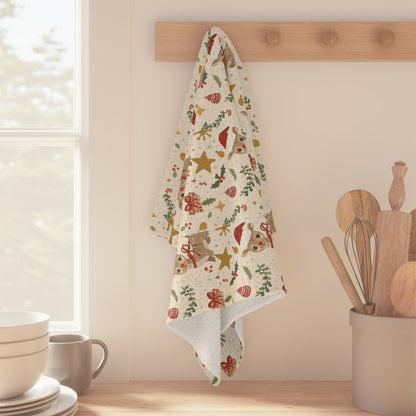 Decorative towel with Christmas patterns hanging on a wooden rack in a kitchen.