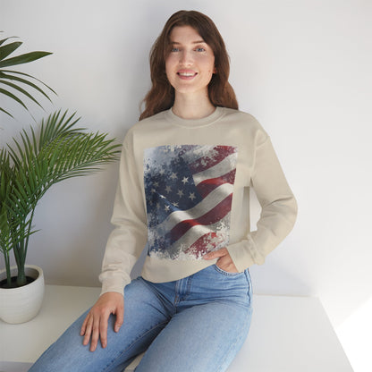 Woman wearing a beige sweatshirt with a vintage American flag design, sitting on a white surface with a plant in the background.
