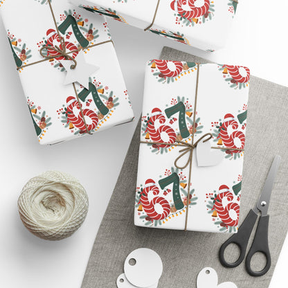 Gift wrap with candy cane and number design on a white surface with scissors and twine.