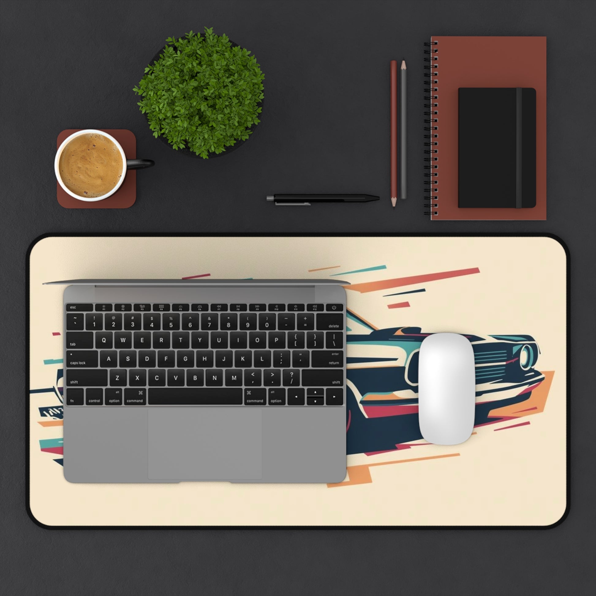 Laptop on a decorative mouse pad with a car design, surrounded by office items on a black background.