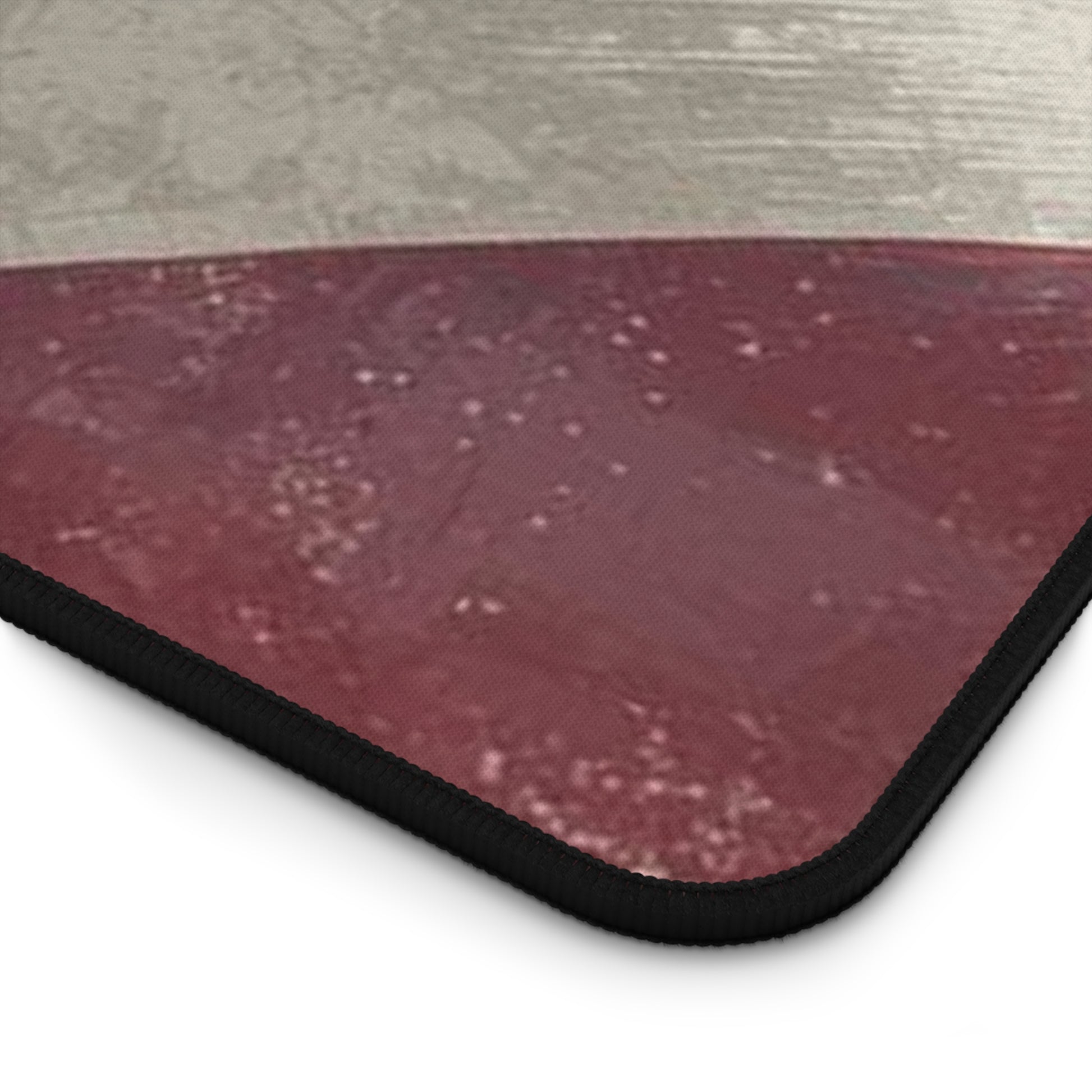 Close-up of a textured red mat with a black border on a light gray background