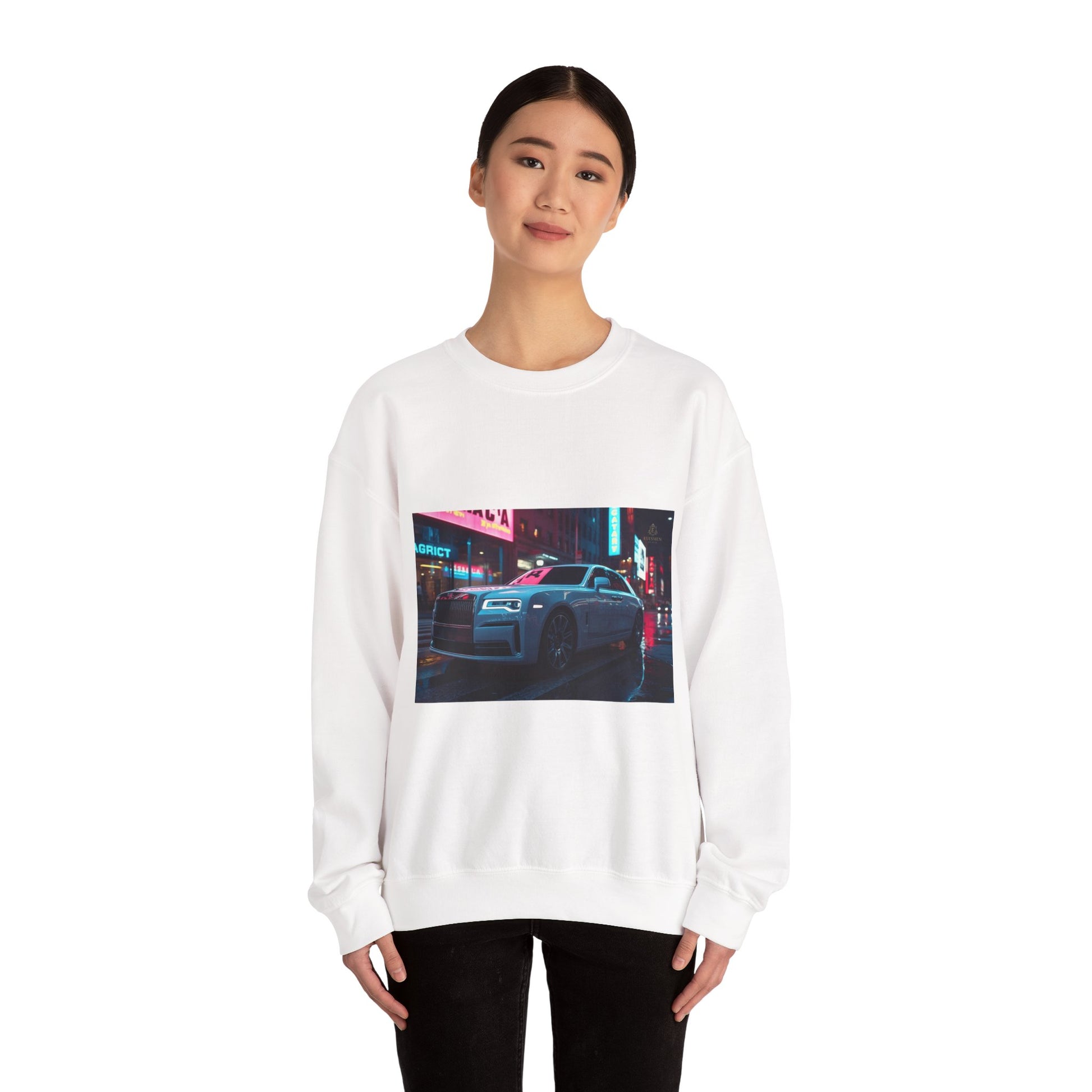 Person wearing a white sweatshirt with a graphic of a car on a city street at night.