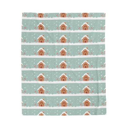Patterned blanket with gingerbread houses on a light blue background