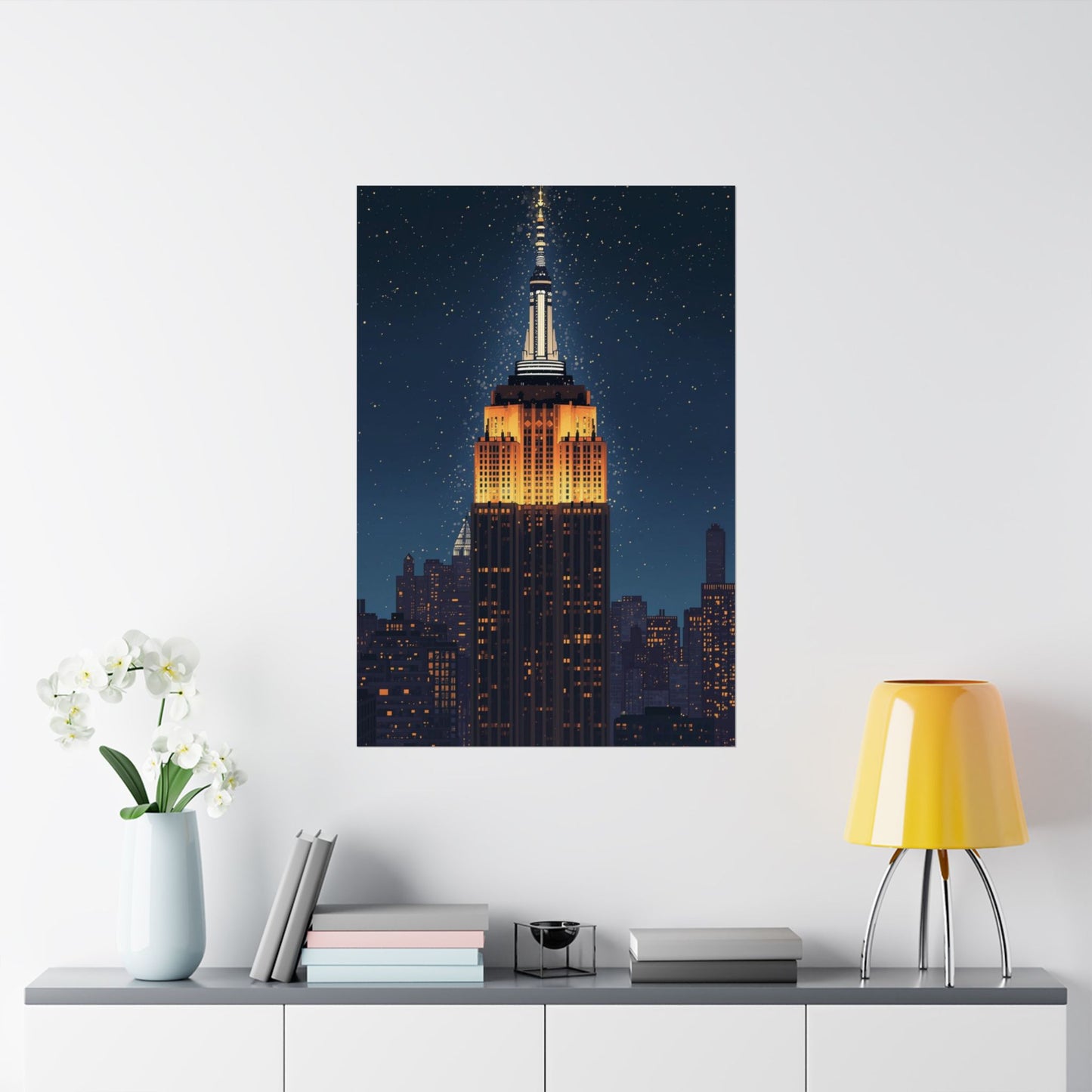 Framed artwork of the Empire State Building on a wall above a shelf with decor items.