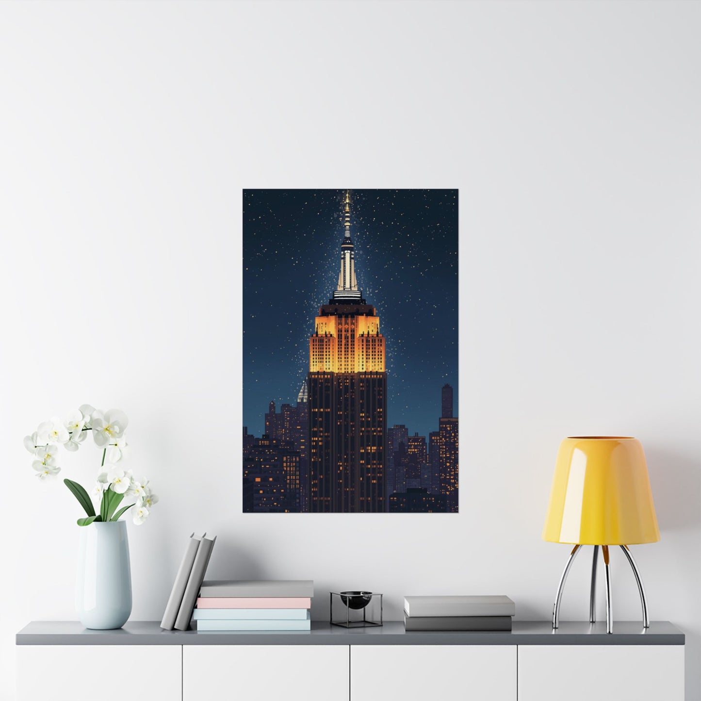 Framed artwork of the Empire State Building on a wall above a table with decor items.