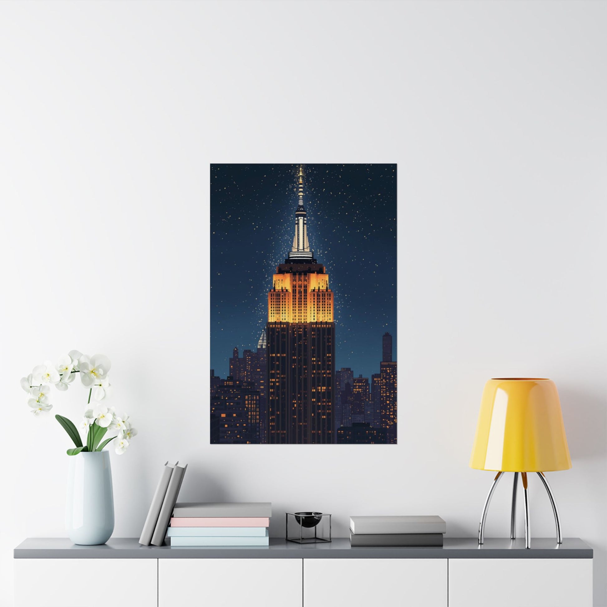 Framed artwork of the Empire State Building on a wall above a table with decor items.